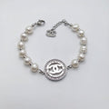 Brazalete de Perlas Naturales y Acero Inoxidable con Medallón Icónico y Cristales